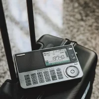An ATS-909X2 shortwave radio sitting on top of luggage